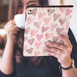 a girl is holding and viewing personalized iPad folio case with Love design